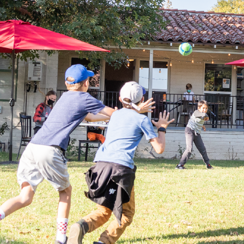 Three pre-teen boys playing catch with a football