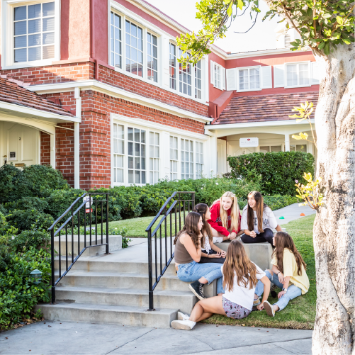 Stepping Stones Learning Center with teenage girls sitting and talking on the front stairs