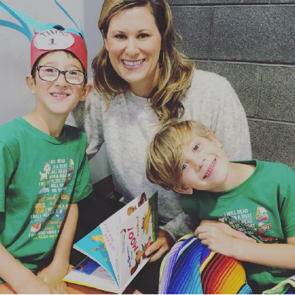 Anna Hasbun sitting centered with two boys reading Dr. Seuss