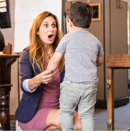 Woman teacher encouraging boy toddler