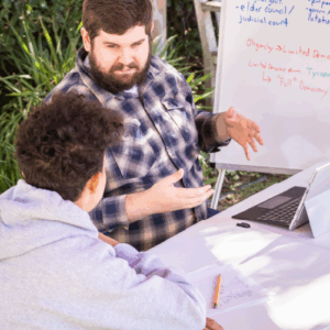 Male tutor explaining concept to teenage boy